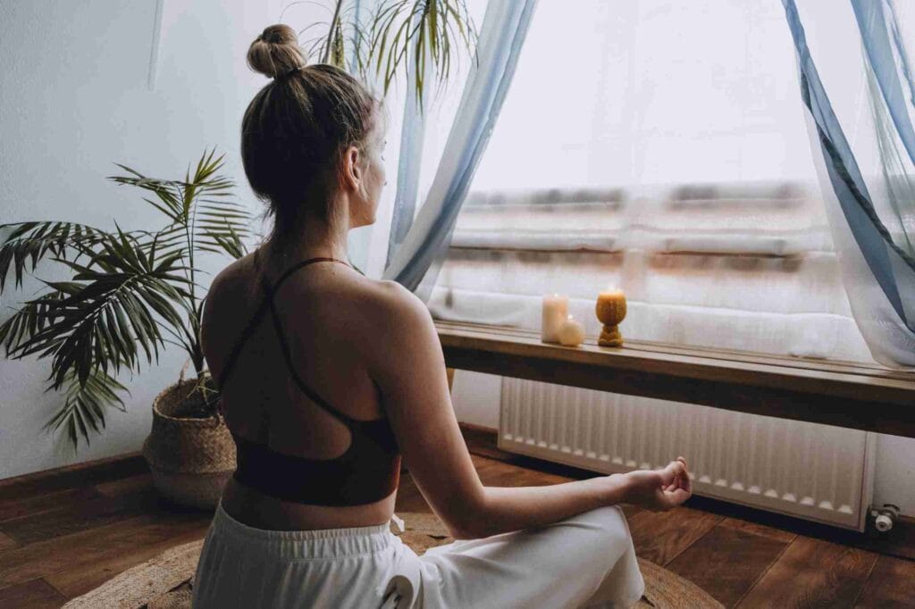 Person meditating by a window.