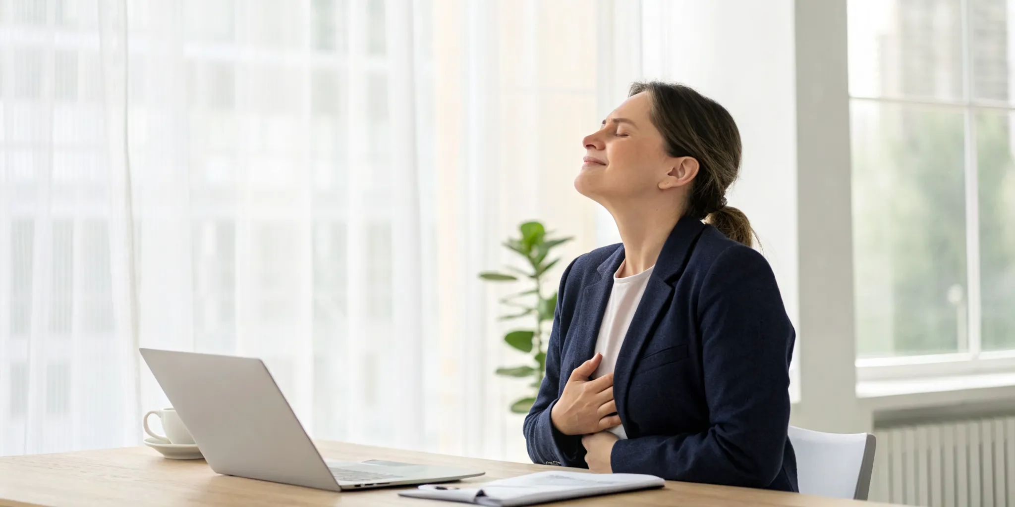 A woman at her desk connecting to her body's wisdom through trauma informed care.